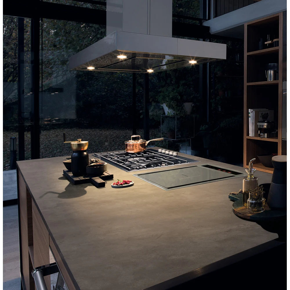 Modern kitchen with a stovetop and countertop in a dark setting
