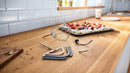 Bosch MUM58359 mixing tools—whisk, flexi beater and dough hook—on a kitchen counter with a berry dessert tray